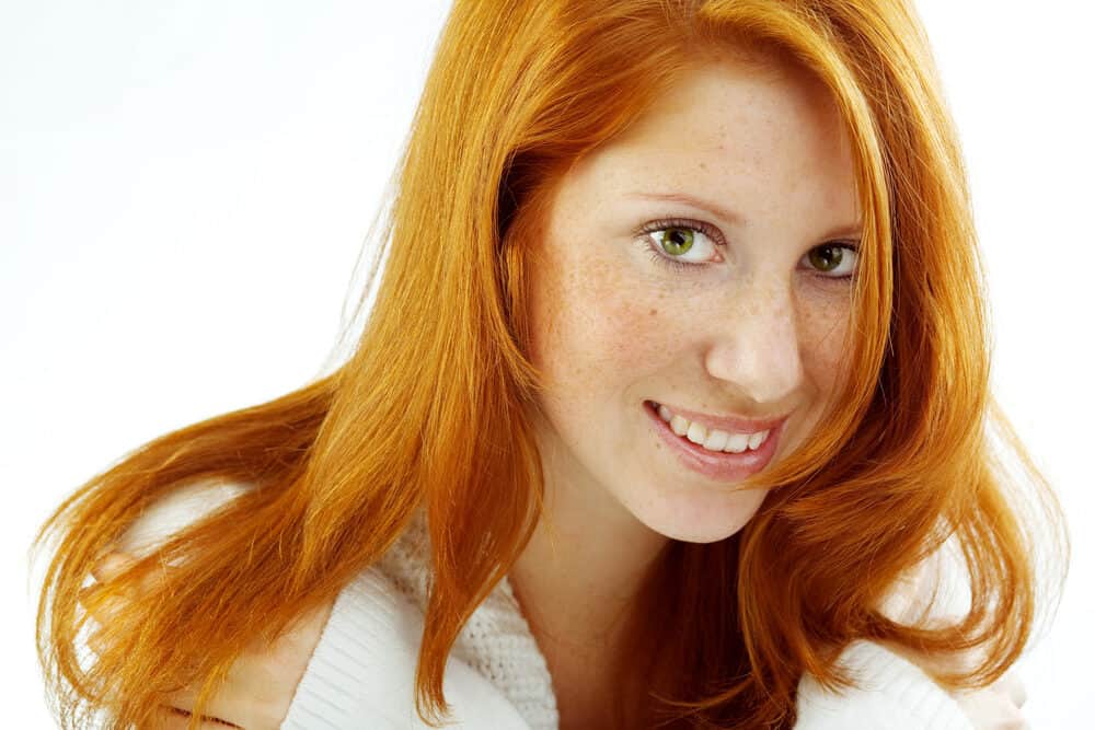 Beautiful white woman with light green eyes and brown hair with cool tones wearing a casual outfit.