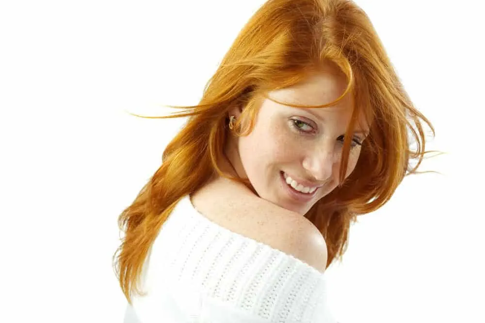 Cute lady looking back over her right shoulder with orange hair from using box dye on her 1C hair type.
