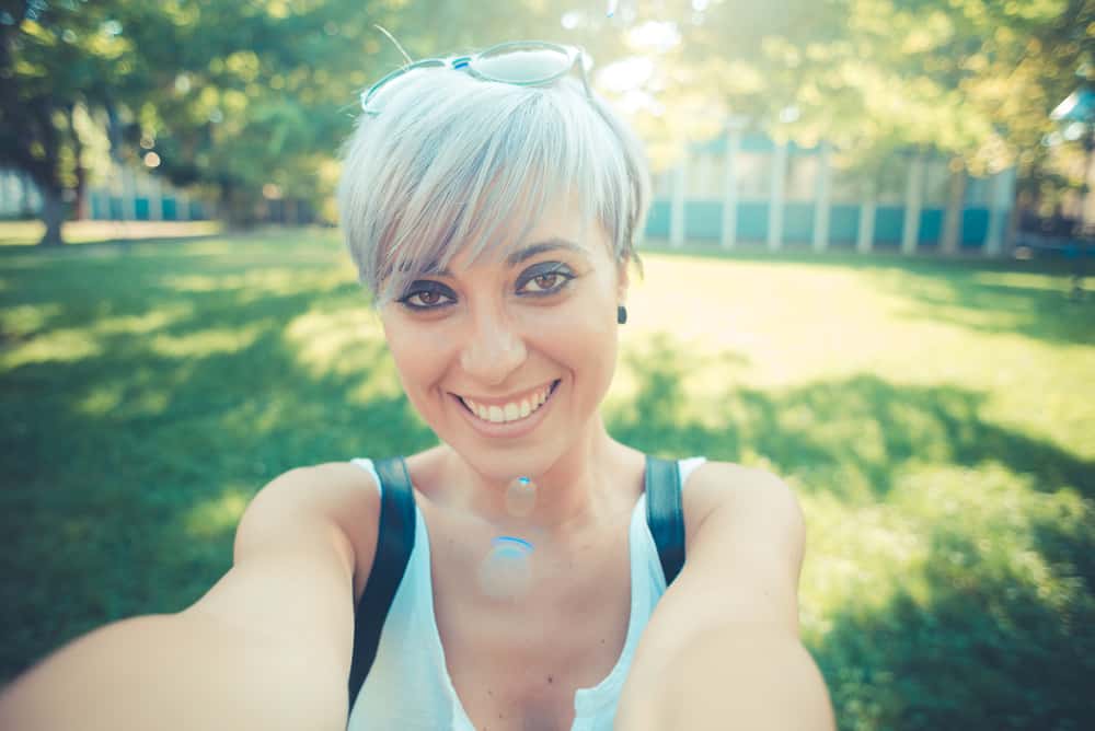 Cute white girl wearing blue eye shadow with natural dark brown with blue tones and a vibrant silver hue.