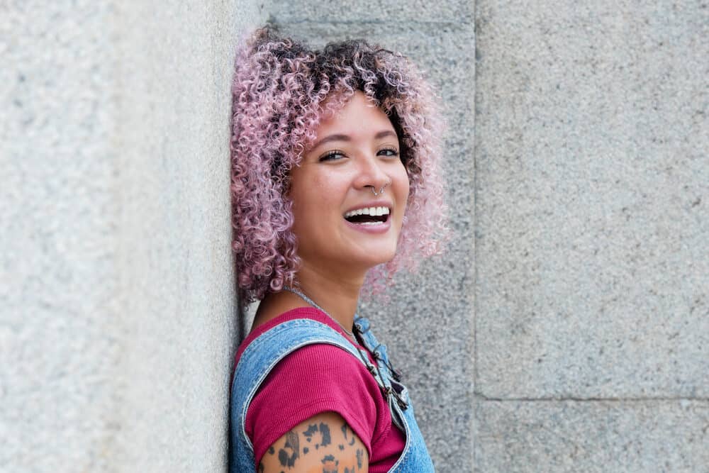 A lady with 3C natural curls that's been dyed pink from a darker hair color with a radiant hair color kit.