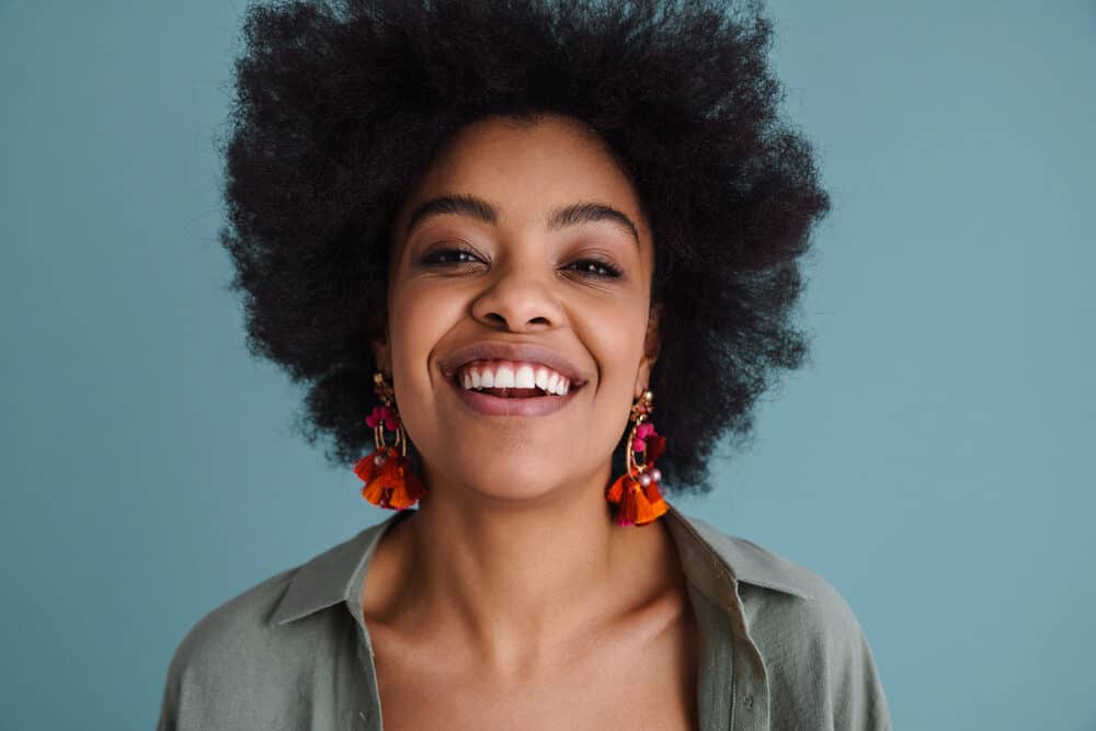 African American female with black hair wearing a green shirt and dark red lipstick.