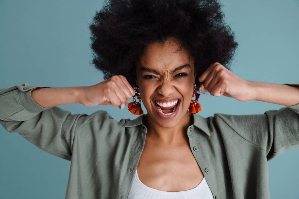 A black woman wearing hair extensions on her 4C natural curls.