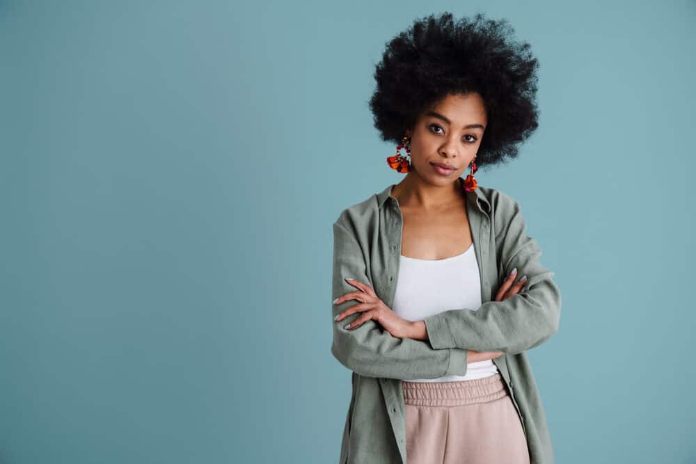 An adult female is wearing a wig over her own natural hair as a protective style.