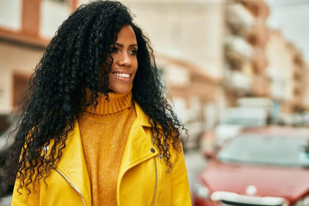 Middle age female using a wig to cover her own hair due to experiencing hair loss along her hairline.