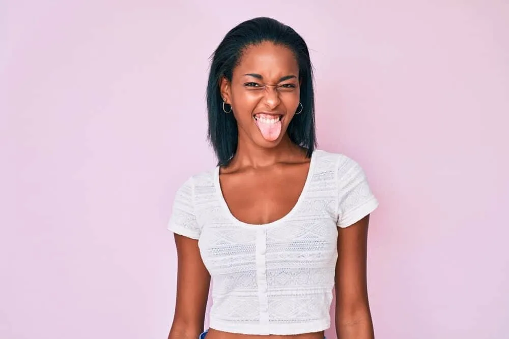 Best Steam Straighteners for Black, Curly, and Natural Hair 9 Young African lady after using a curling iron with adjustable heat settings and heated plates.