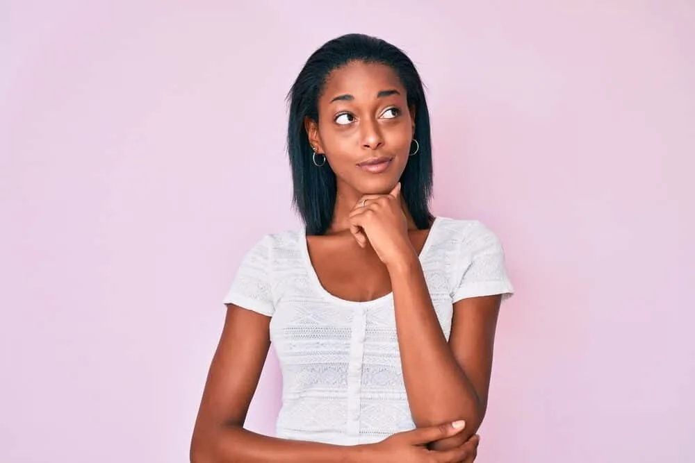 Best Steam Straighteners for Black, Curly, and Natural Hair 12 Young African American lady enjoying her hair's natural moisture after using a heat protectant spray to style her curls.