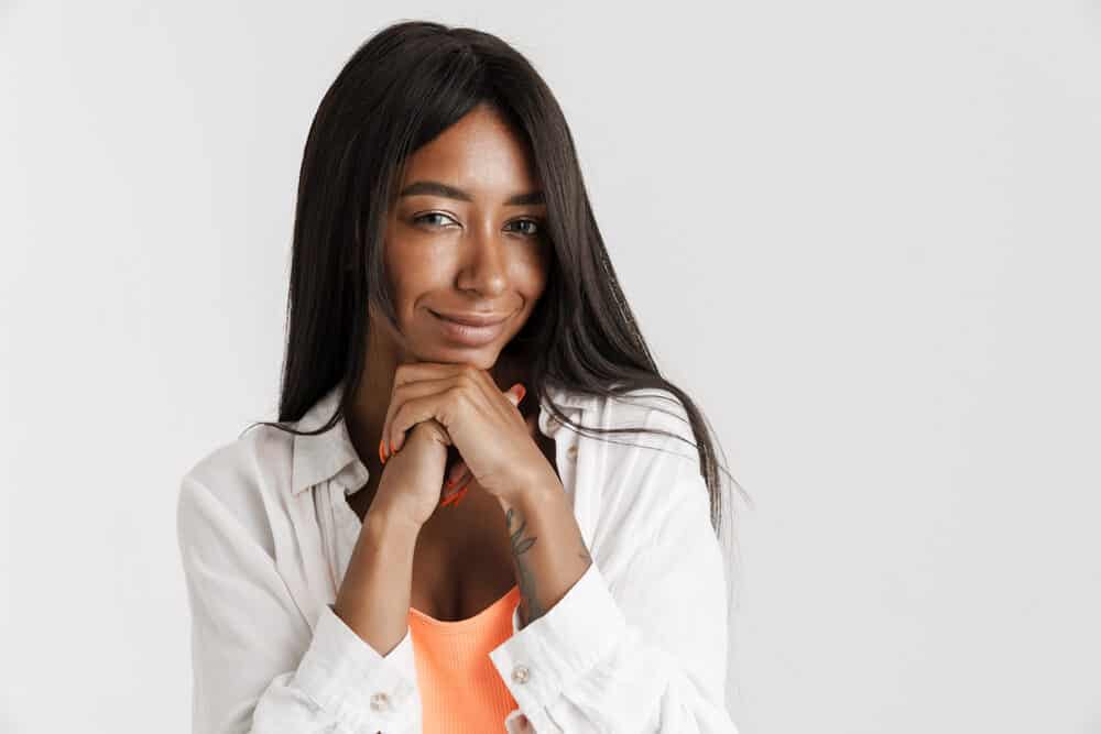 Young black lady with a beautiful smile wearing a good quality hair wig with a cap construction.