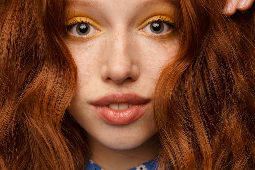 Young ginger white woman with an orange hair color after using a semi-permanent direct dye with copper tones.