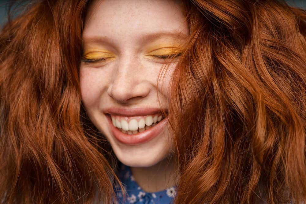 Young Caucasian woman wearing lunar tides hair dye on 1C hair follicles with an olive skin tone.