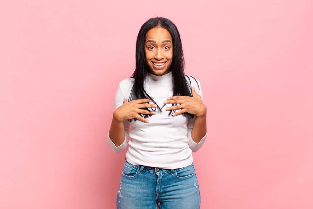 Black woman with a type 4 hair type is wearing her hair completely dry after straightening it.