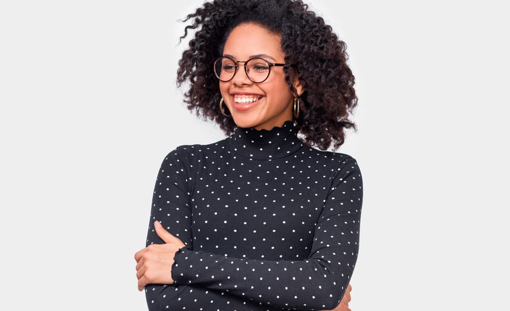 Adult female with light skin wearing a polka dot turtle neck shirt.