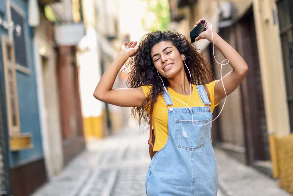 A young girl wearing overalls with a medium-length naturally straight hair type.