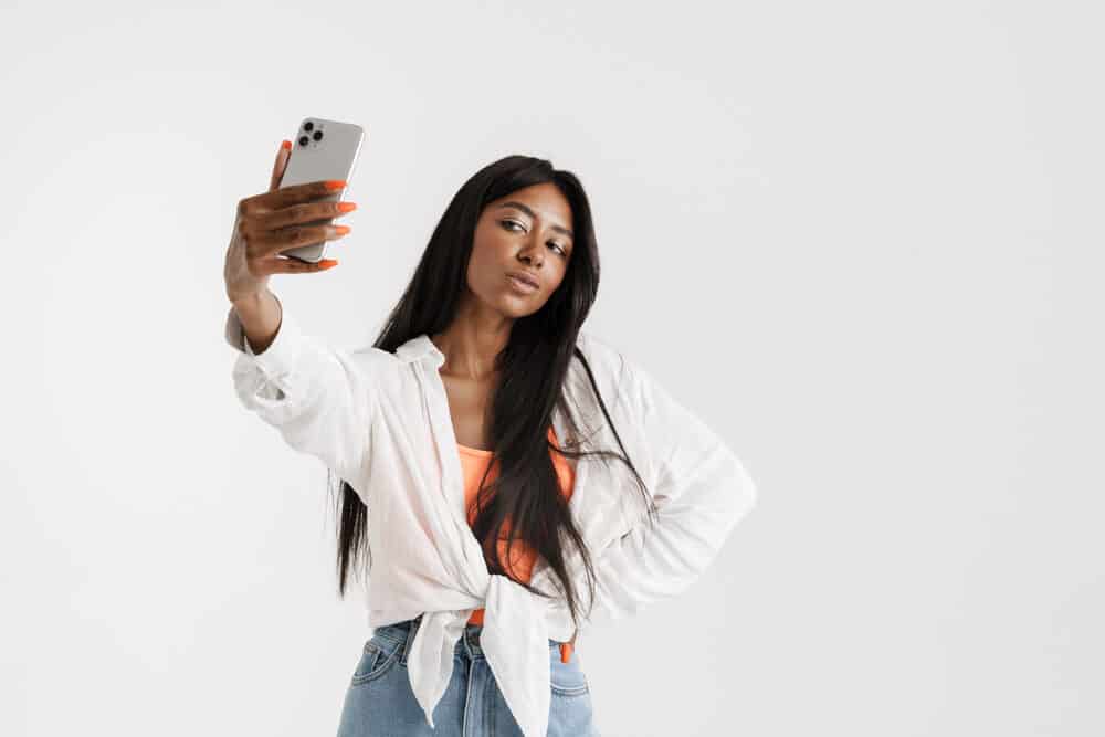 Young African American woman taking a selfie of her pre-styled stocking cap wig design.