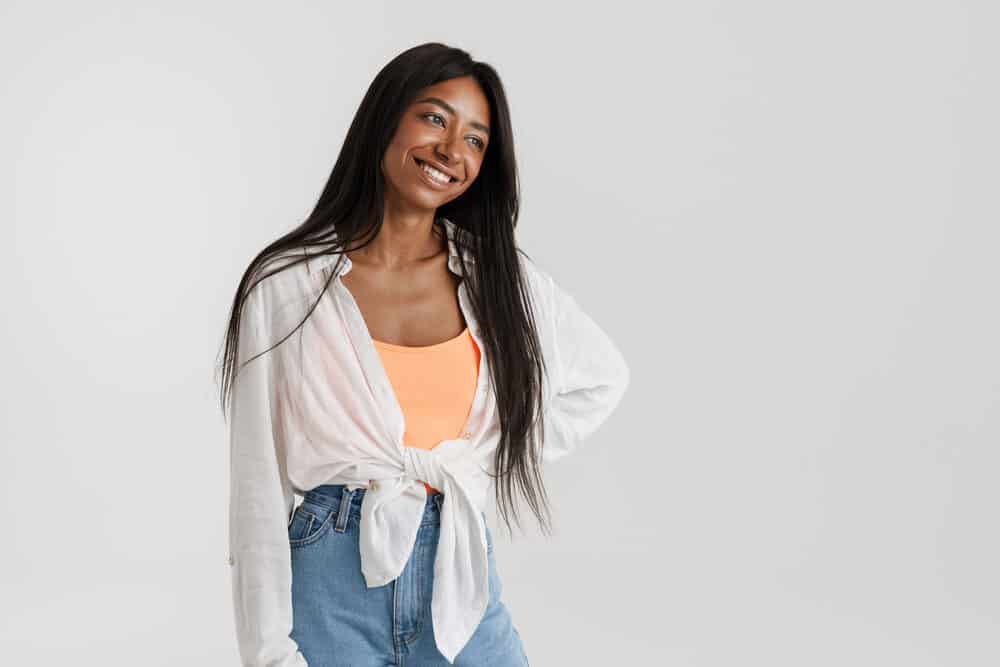 Happy young African female wearing a human hair wig with a cap construction that has a natural look.