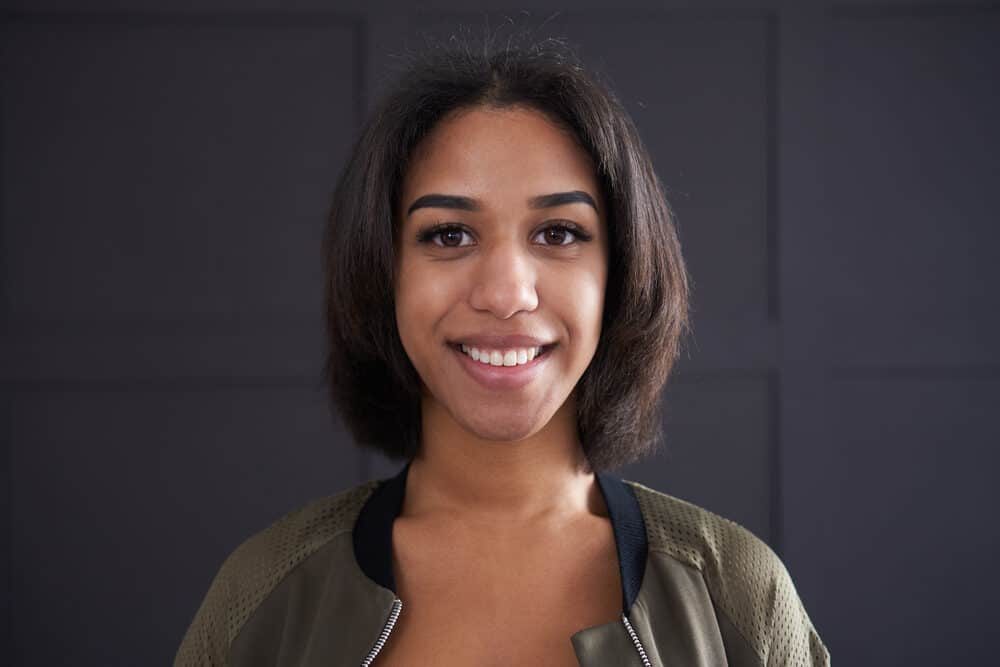 A beautiful black girl after straightening dirty hair with a curling iron with adjustable temperature controls.