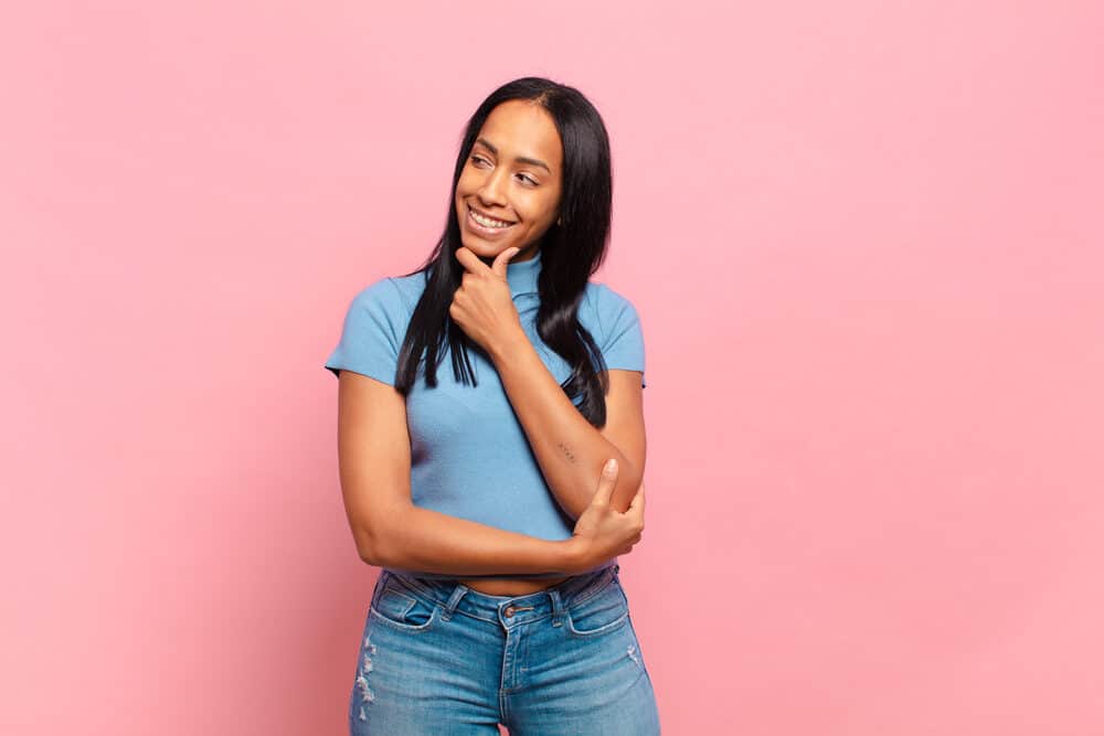 Beautiful African American female with split-end hair damage from using ceramic flat irons on wet hair strands.