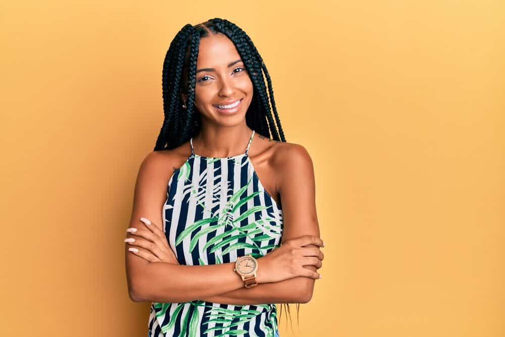 Beautiful Hispanic woman wearing box braids on her 3C natural hair with a blue and green shirt.