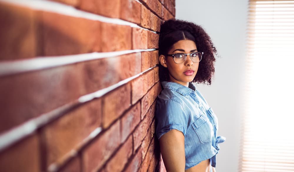 A cute young stylish black lady wearing a blue jean shirt and a 360 wig.