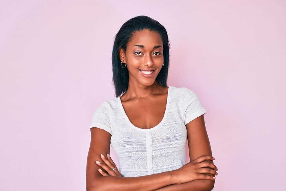 African American female with natural black hair wearing a bone-straight hairstyle created with a straightening iron.