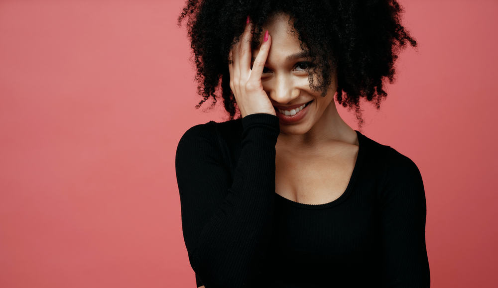 Cute black female with a great smile wearing a twist-out style created with silk protein and moisturizing cream.