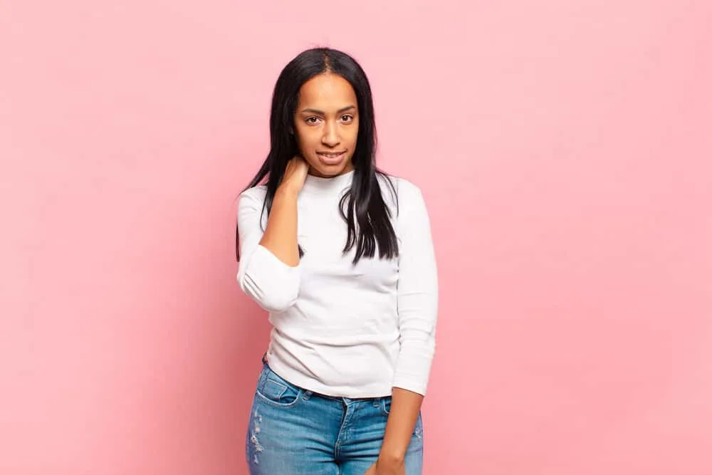Can You Use Hairspray Before Straightening Your Hair? 11 Confidently female wearing her hair straight after using a curling iron to straighten her coarse hair strands.