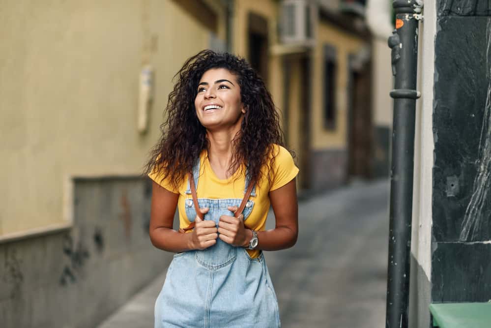 Cute African lady with a natural straight hair falling flat against her face and shoulders.