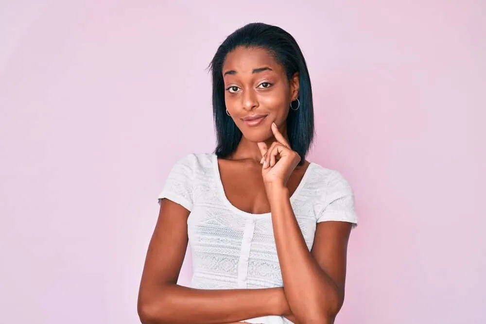 Best Steam Straighteners for Black, Curly, and Natural Hair 11 Black girl wearing a subtle smile on her face after flat ironing her previously wet hair strands.