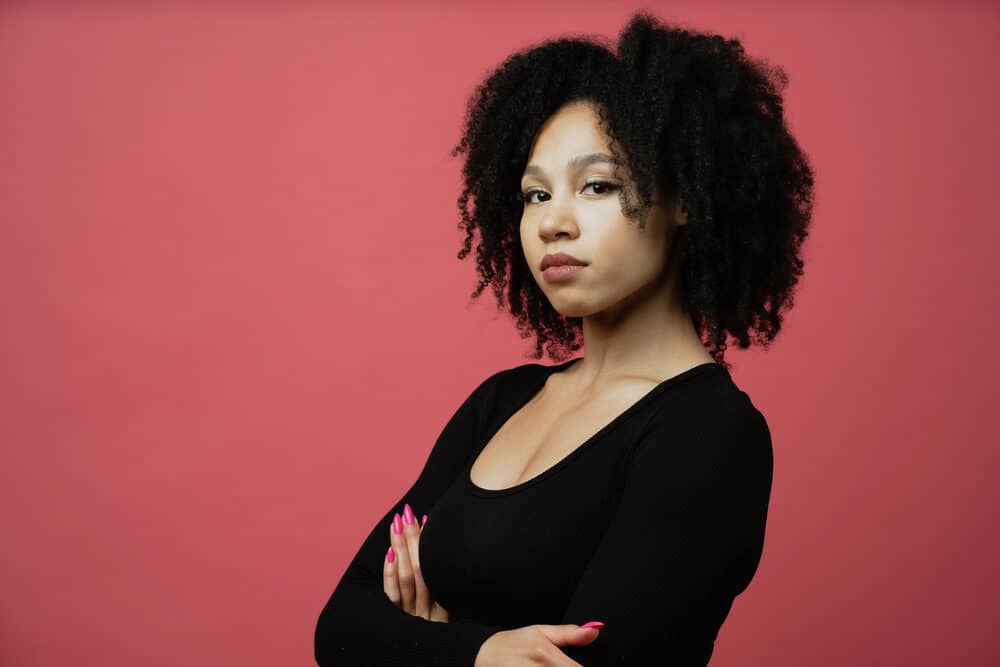 Serious looking black girl surfing some signs of protein overload with kinky curls styled with coconut oil.