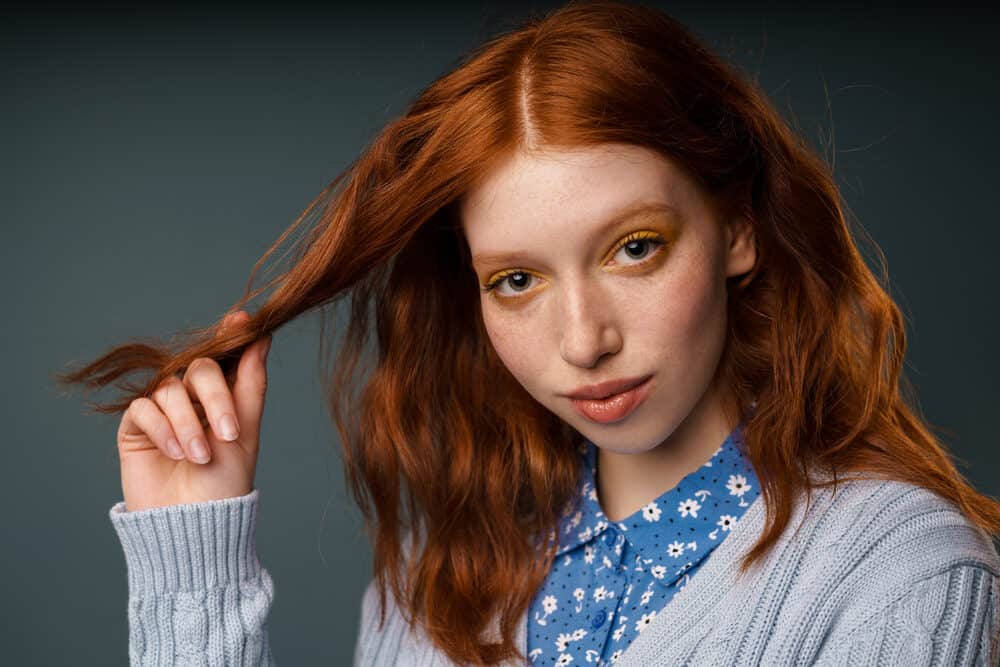 Caucasian female with a crazy color hair dye that looks like sunrise orange and bright auburn.