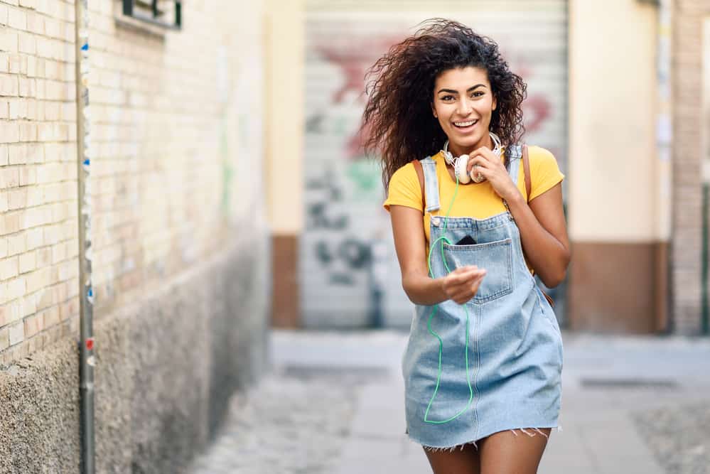 A female wearing a casual outfit and a wavy hair cut after sporting a silk durag overnight.