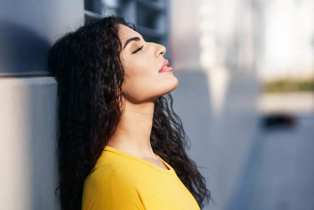 How to Get Waves With Straight Hair for Beginners: Step by Step 13 A young mixed-raced woman with a straight hair texture created loose waves with sea salt spray.