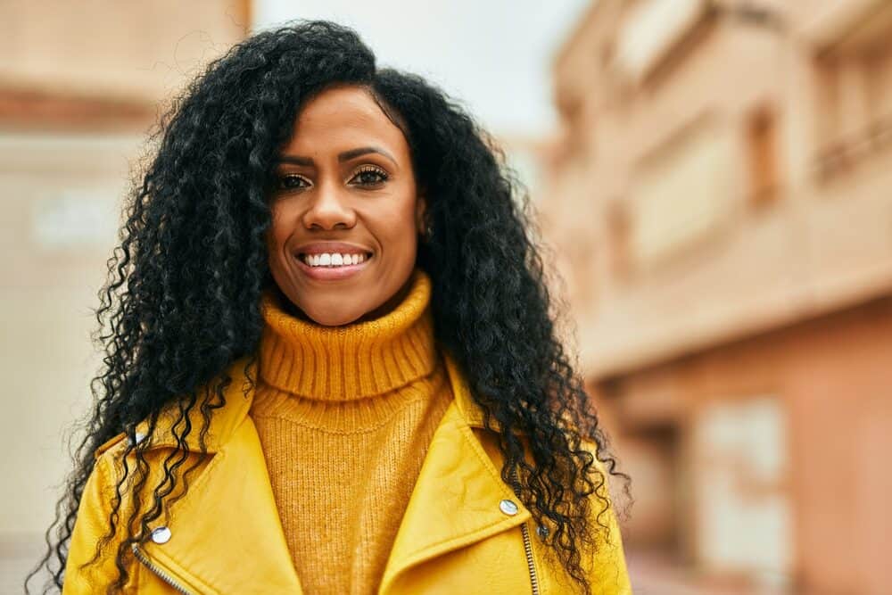 Middle age African American woman with 4C natural hair wearing a full lace wig secured with wig clips.