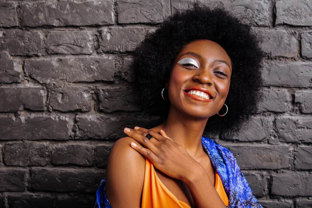 A black lady that's a part of the natural hair community wearing a wash n go hairdo on her coarse hair.