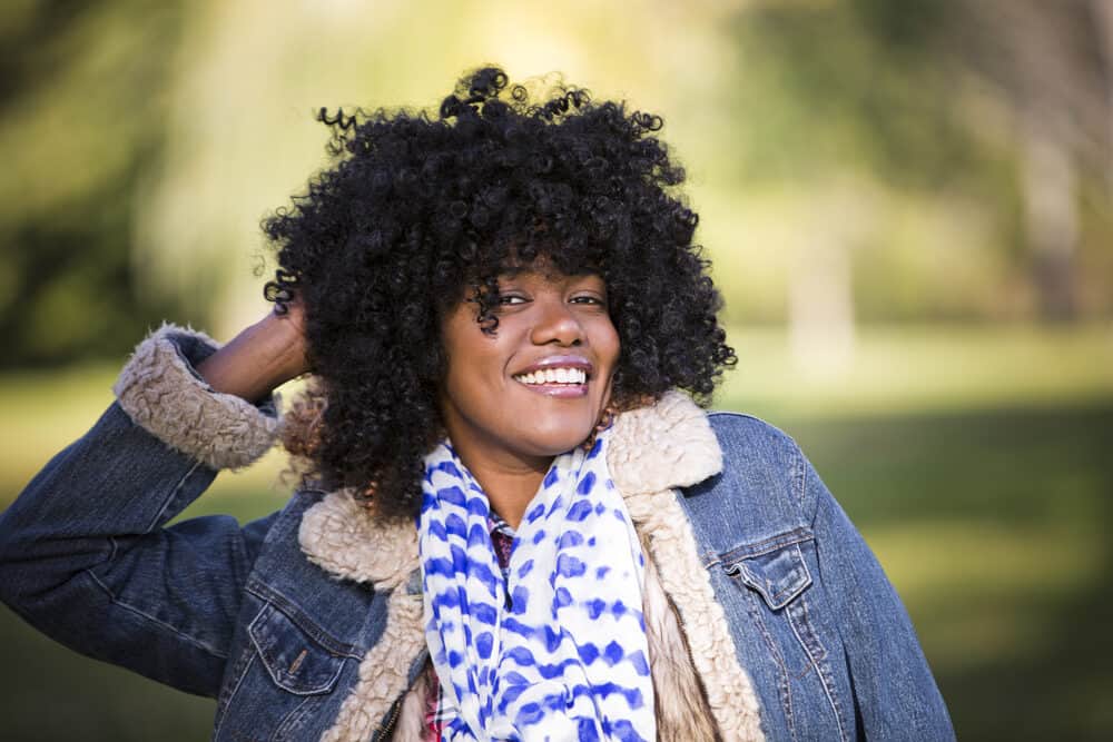A black female with thin natural hair wearing a human hair wig to cover her thinning hair strands.