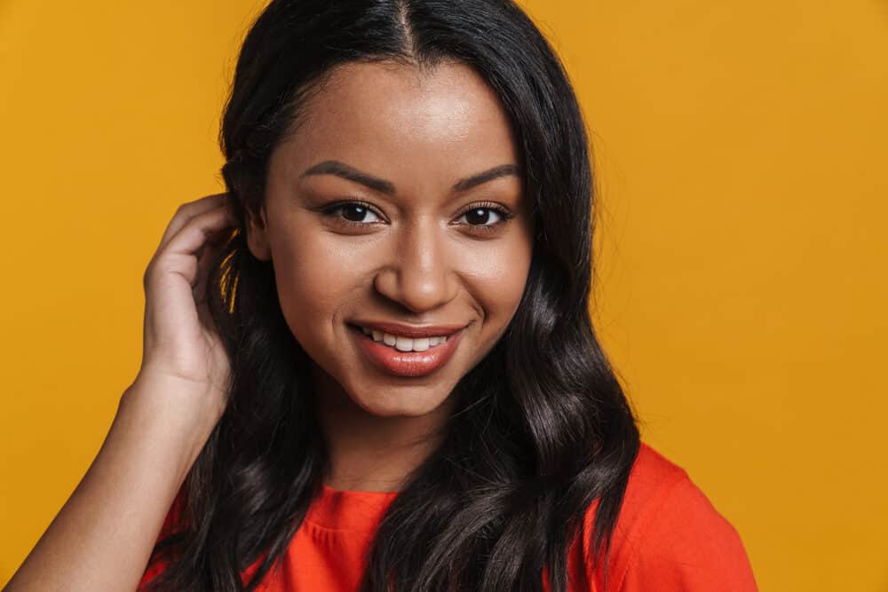 An African American female with color-treated hair used a hair straightener with protective styling gel.