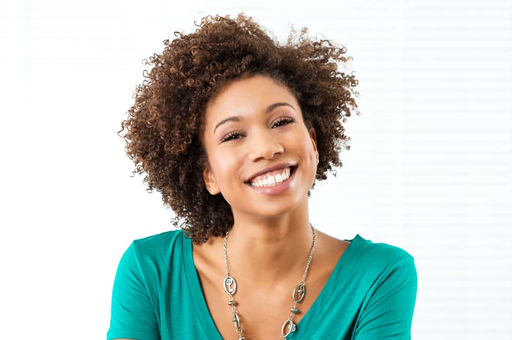 The Benefits of Neem Oil for Hair, Scalp, and Skin Conditions 1 African American female with shiny hair wearing a kinky twist-out styled with organic neem oil.
