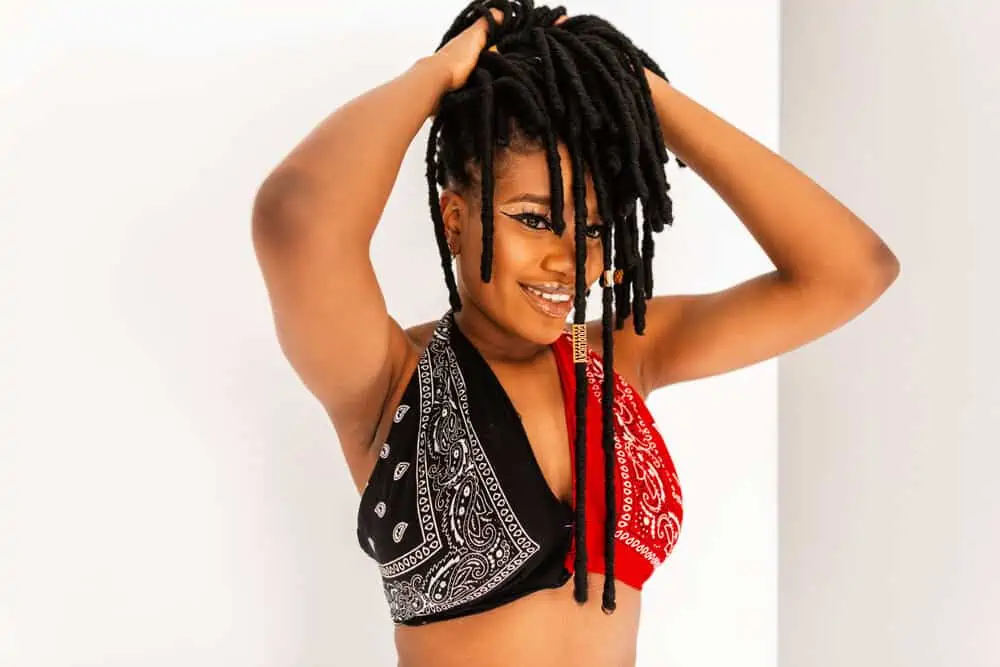 Pretty young African woman with braided hair forming matted locks as she embraces her African American culture.