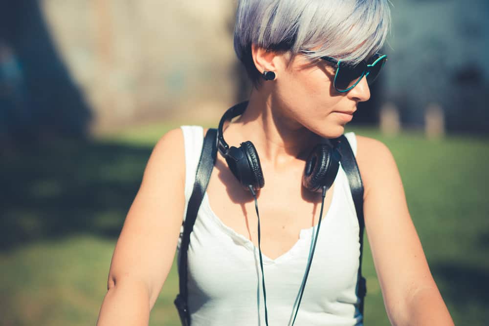 Cute caucasian female after dyeing her dark hair blue enjoying a sunny day outside.