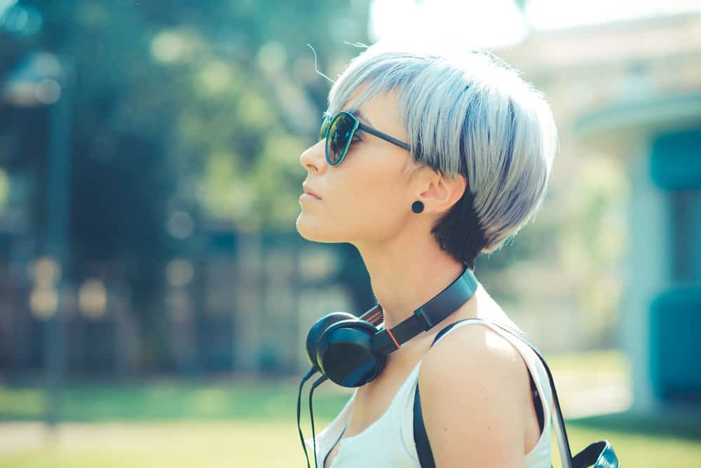 Young hipster with electric blue bleached hair strands created with midnight blue hair dye.