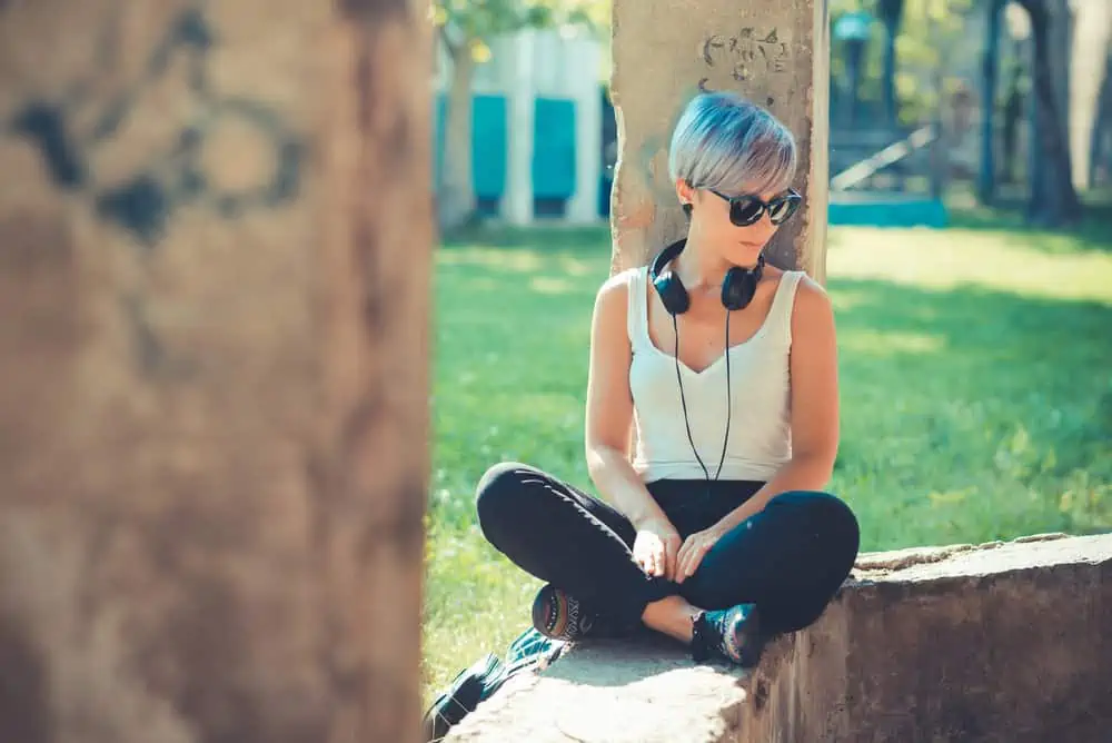 The Best Blue Hair Dyes for Dark Hair Plus Alternatives 11 A young, fair-skinned woman with a pale skin tone and light brown hair is shown after dyeing her hair a vibrant shade.