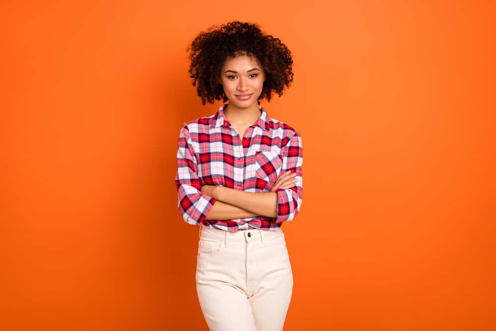 An attractive young woman with light brown hair after using hydrogen peroxide to lighten her curls.