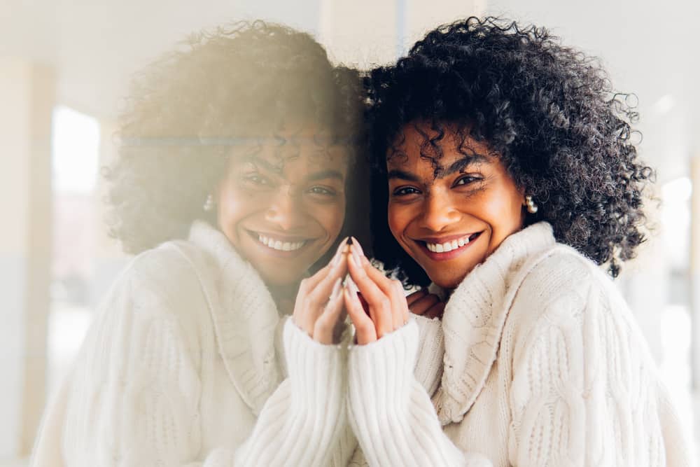 African American woman wearing her curls a black hair color after undergoing the hair coloring chemical process.