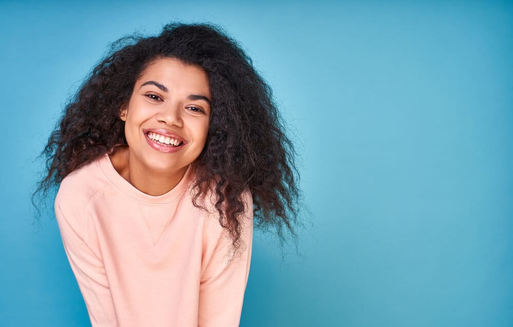 A lovely curly-haired young female with healthy hair after using a specially formulated shampoo for wavy hair.