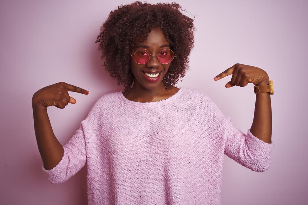 African American lady covering her real hair with a weave sewn to cornrows to grow-out damaged hair.