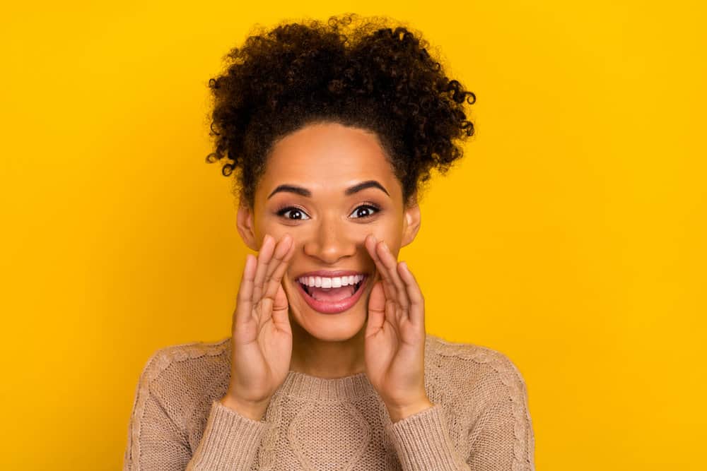 Young black woman with rapidly growing hair after taking essential vitamins designed for hair growth.