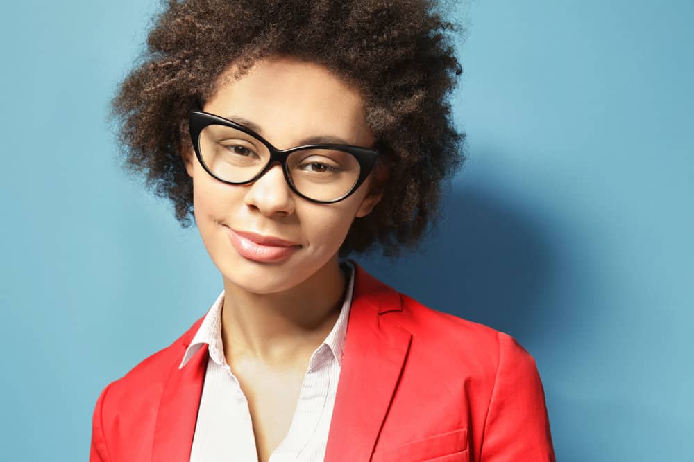 Beautiful African American female with dyed hair strands after undergoing a natural hair coloring treatment.