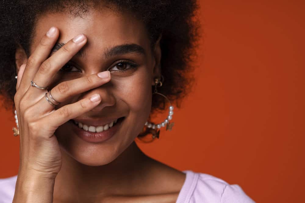 An African American woman after using a moisturizing conditioner on her 4B natural curls.