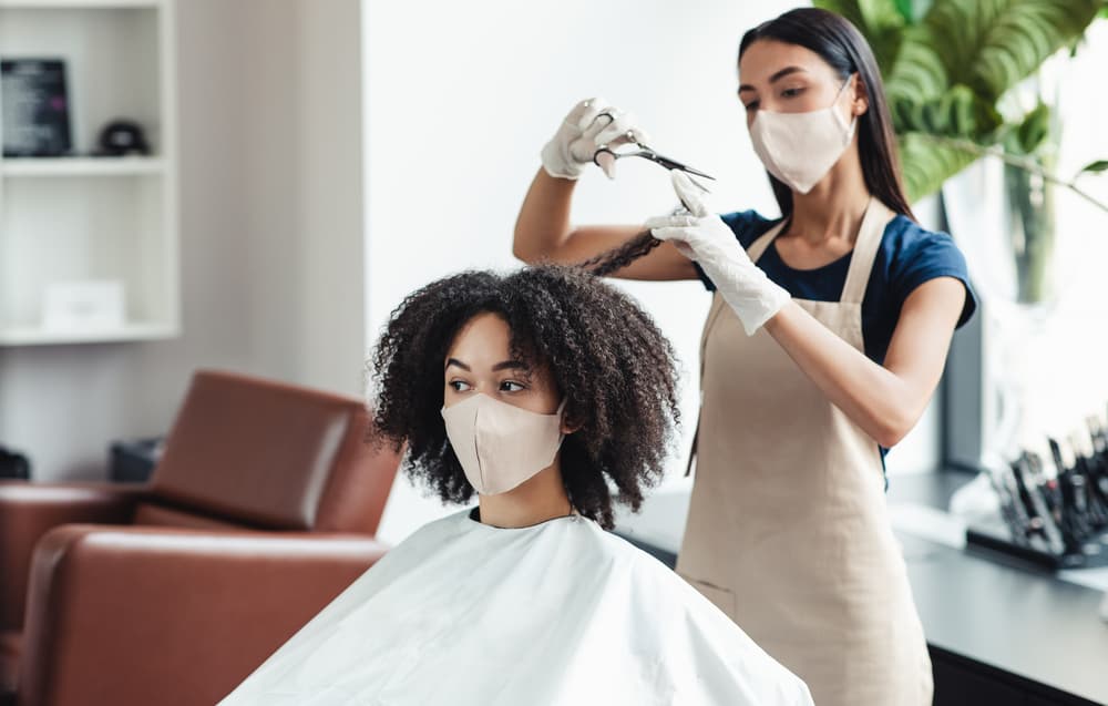 Professional stylist within a Walmart hair salon giving a haircut before a hair color treatment.