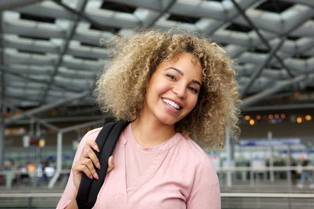 African American female with electric hair clippers and hair attachments in her carry-on luggage.