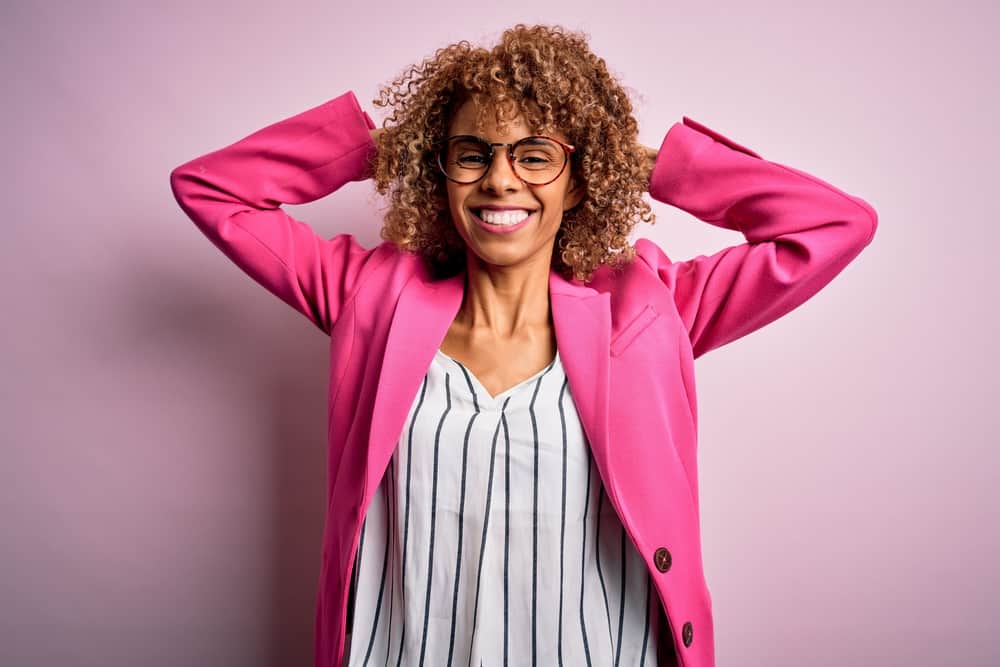 Young African American female wearing blonde semi-permanent hair color on her curly hair cuticles.